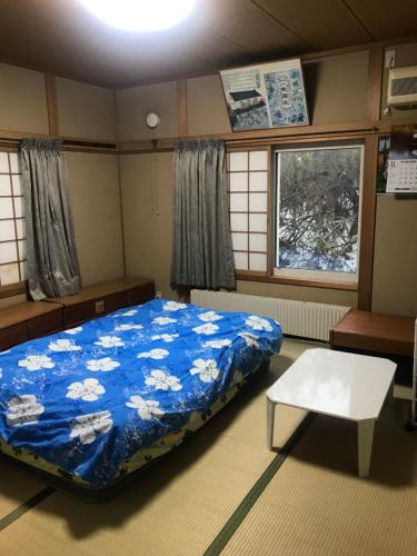 Una habitación con una cama y una mesa dentro. en Sunny house, en Otaru
