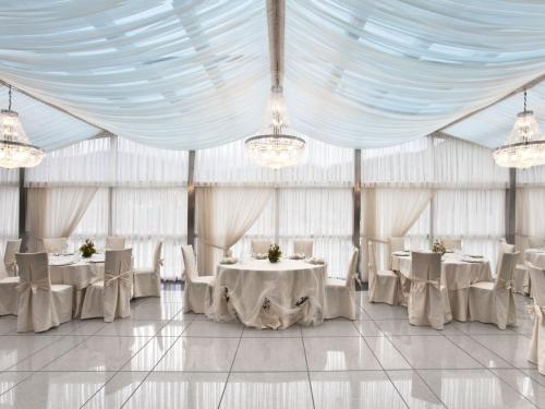 een tent met witte tafels en stoelen en kroonluchters bij Hotel Dei Principati in Baronissi