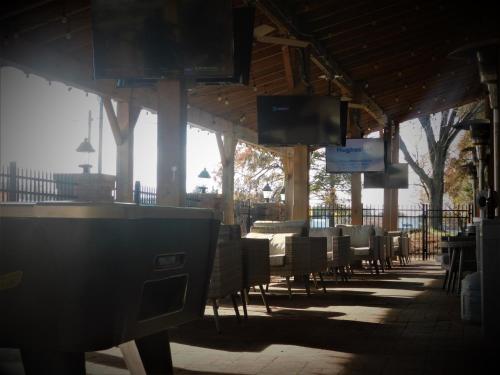 a patio with tables and chairs and televisions at Wyndham Garden Greensboro in Greensboro