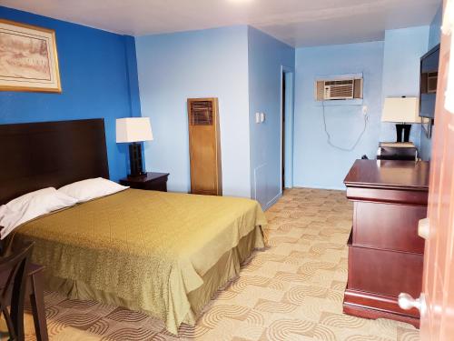 A bed or beds in a room at TRADE WINDS MOTEL
