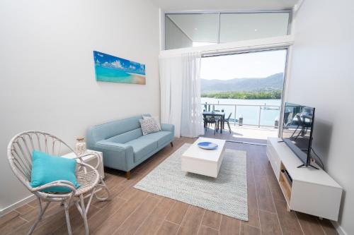 a living room with a couch and a tv at Harbour Cove in Airlie Beach