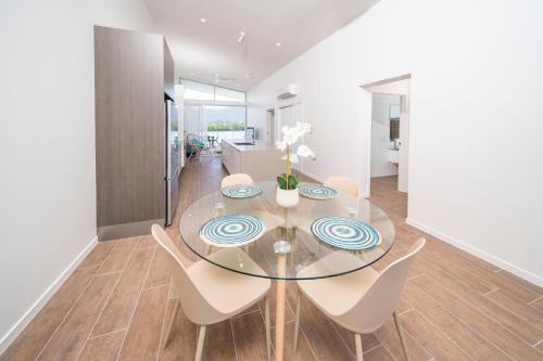a dining room with a glass table and chairs at Harbour Cove in Airlie Beach