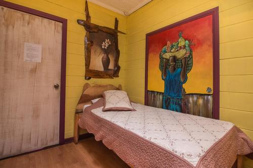 a bedroom with a bed and a painting on the wall at Casa Antigua Hotel in Alajuela City