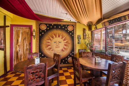 a restaurant with two tables and a sun painting on the wall at Casa Antigua Hotel in Alajuela City