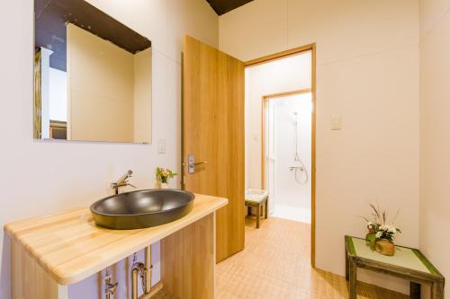 a bathroom with a sink on a wooden counter at Tessen Guesthouse in Shizuoka
