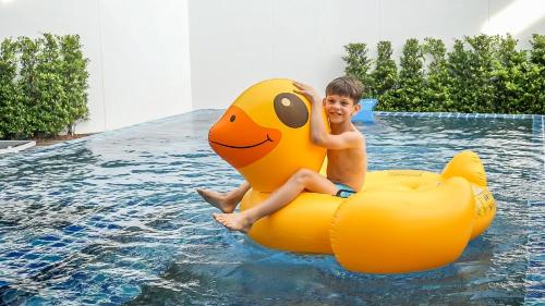 a young boy is sitting on an inflatable at Happy Family Villa in Phuket Town
