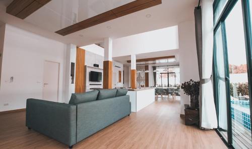 a living room with a couch and a kitchen at Happy Family Villa in Phuket Town