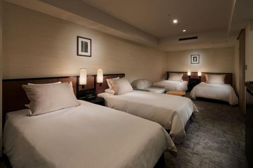 a hotel room with two beds and two lamps at Hotel Granvia Kyoto in Kyoto