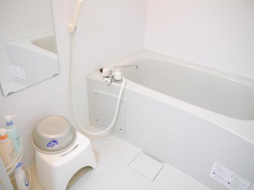 a white bathroom with a toilet and a sink at Fukuoka Condominium in Fukuoka