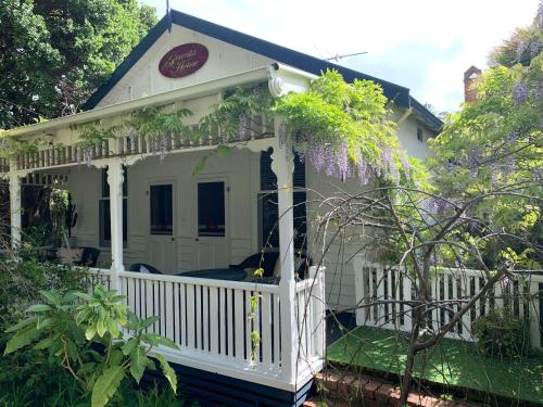 a white house with a white fence and trees at Genesta House in Cowes
