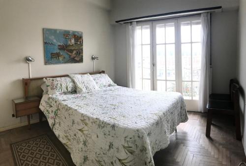 ein Schlafzimmer mit einem Bett und einem großen Fenster in der Unterkunft Frente al Mar y Casino - La mejor ubicacion en Mar del Plata in Mar del Plata
