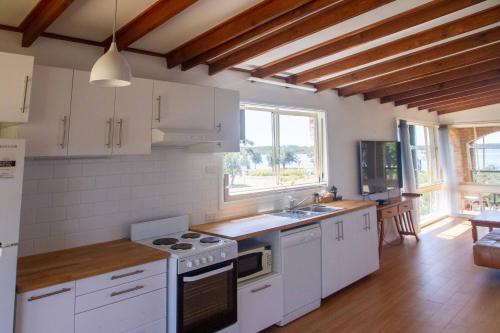 a kitchen with white appliances and a large window at South Coast Retreat in Greenwell Point