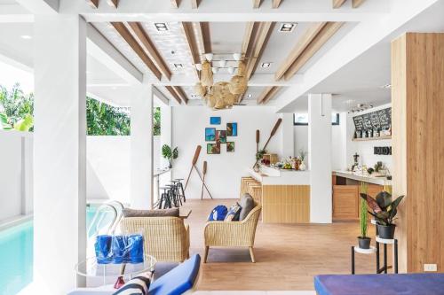 una sala de estar con paredes blancas y techos de madera. en Kokotel Krabi Oasis en Ao Nang Beach