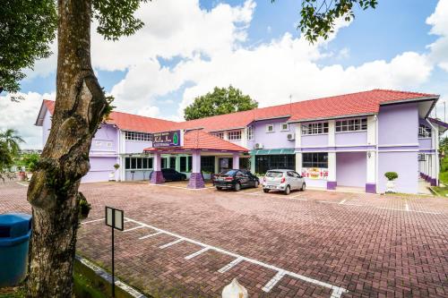un edificio con un'auto parcheggiata in un parcheggio di Hotel O Kulim Inn a Kulim