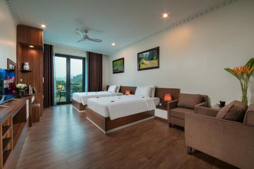 a hotel room with a bed and a couch at Tam Coc Holiday Hotel & Villa in Ninh Binh