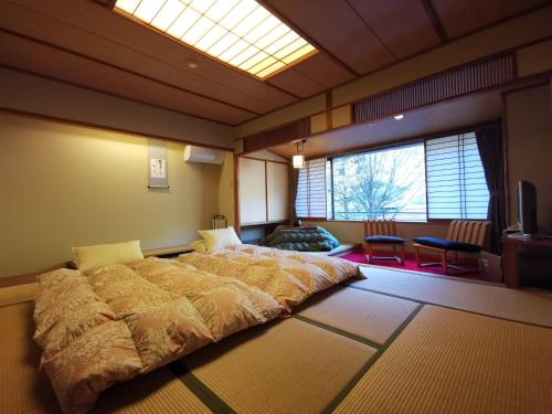 a large bed in a room with a large window at Sakahijiri Nikko in Nikko