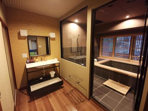 a bathroom with a shower and a sink and a mirror at Sakahijiri Nikko in Nikko