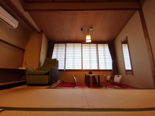 a living room with a chair and a table at Sakahijiri Nikko in Nikko