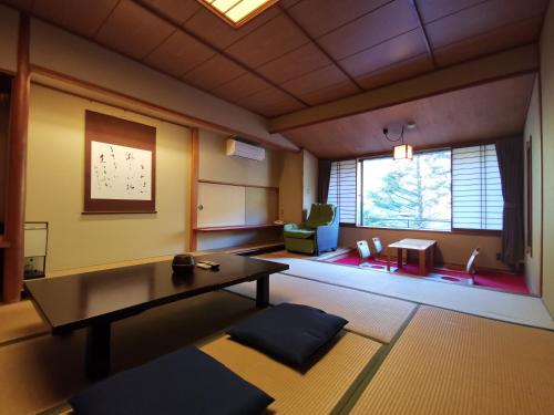 a living room with a table and a chair at Sakahijiri Nikko in Nikko