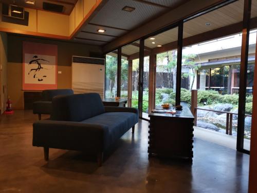 a living room with a couch and chairs and windows at Sakahijiri Nikko in Nikko