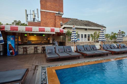 a swimming pool with lounge chairs next to a building at Buddy Lodge, Khaosan Road in Bangkok