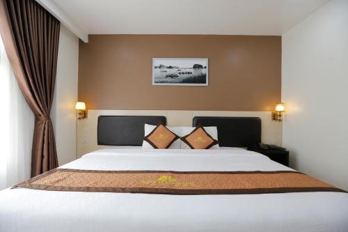 Un dormitorio con una gran cama blanca con dos almohadas. en Bảo Hân 2 Hotel, en Ha Long
