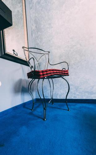 a red chair sitting in a room next to a wall at Vila 6aTo Hotel & Wellnes in Sofia