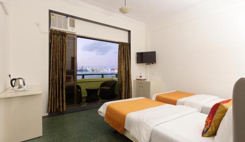 a hotel room with two beds and a window at Sea Green South Hotel in Mumbai