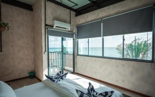 a bedroom with a large window with a view of the ocean at Tranquil Nest Vaavu in Rakeedhoo