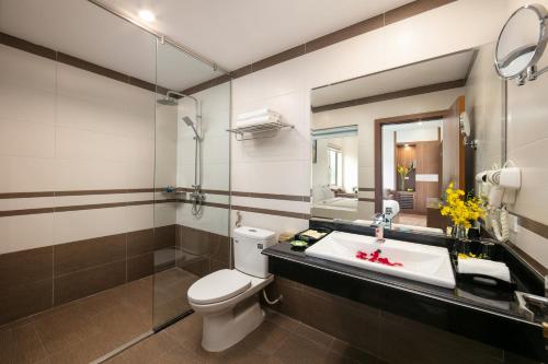 a bathroom with a sink and a toilet and a mirror at Tam Coc Holiday Hotel & Villa in Ninh Binh