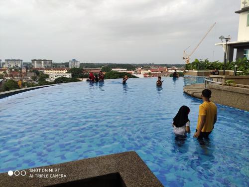 grupa ludzi stojących w basenie w obiekcie DPerdana -Dinies pool,wifi, centre of Kota Bharu, 4-5 pax w mieście Kota Bharu