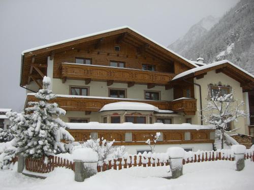 a building covered in snow with a fence at Gästehaus Falkner Ignaz in Sölden