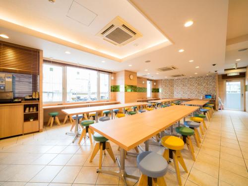 a cafeteria with wooden tables and stools at Super Hotel Nagoya Ekimae in Nagoya
