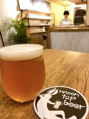 a glass of beer sitting on top of a table at Private House HidaTakayama in Takayama