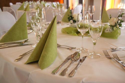 une table avec des serviettes vertes et de l'argenterie dans l'établissement Gasthof Grofe, à Effeln