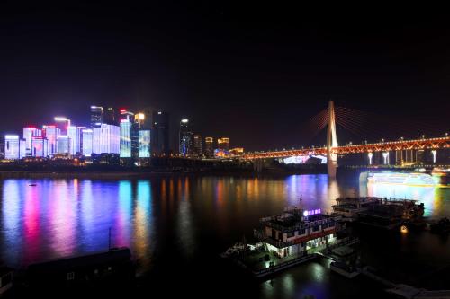 a bridge over a river with a city at night at Zou Qu Ye Travel Hotel in Chongqing