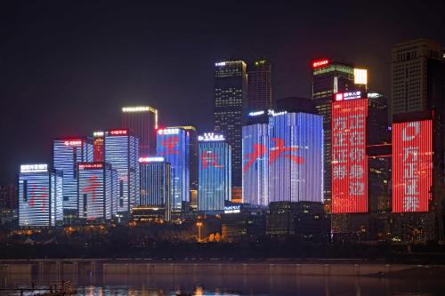 a city skyline at night with red and blue lights at Zou Qu Ye Travel Hotel in Chongqing