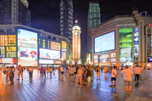 a crowd of people walking in a city at night at Zou Qu Ye Travel Hotel in Chongqing