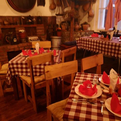 a restaurant with tables and chairs with red hats on them at Etno Konak Angela in Kalna