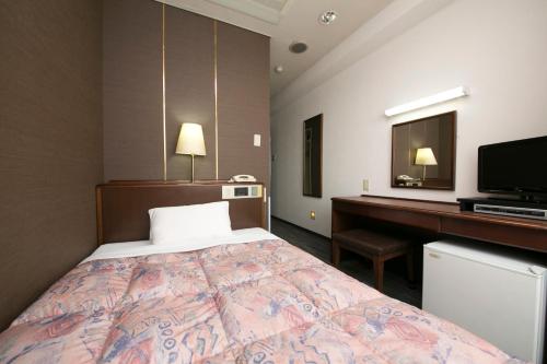 una camera d'albergo con letto e scrivania di Nawa Plaza Hotel a Tokai