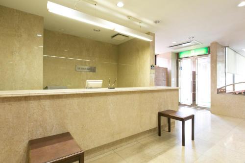 una sala de espera con un mostrador y un espejo en Nawa Plaza Hotel, en Tokai