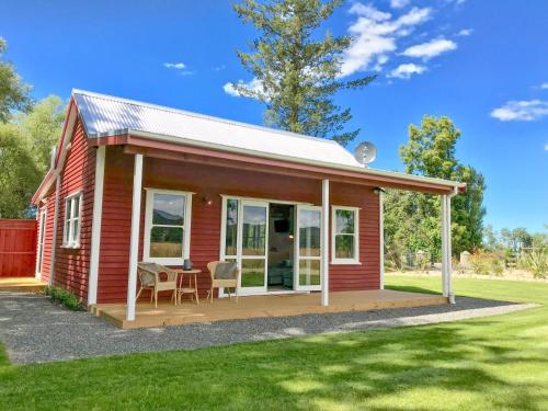 a red tiny house with a porch and a patio at Red Cottages Staveley in Staveley