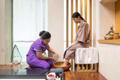 a woman kneeling on the floor next to another woman at Sivatel Bangkok Hotel in Bangkok