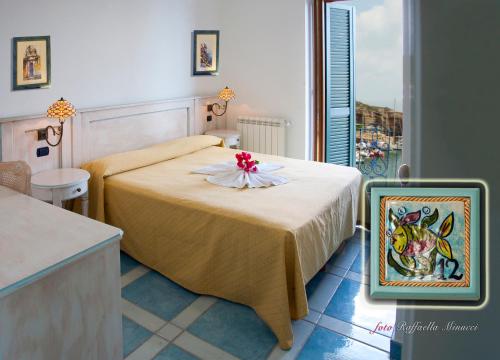 Un dormitorio con una cama con una flor. en Hotel Isolabella, en Ventotene