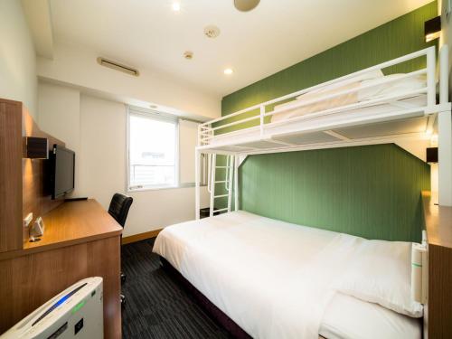 una camera con letto e letti a castello di Super Hotel Nagoya Ekimae a Nagoya