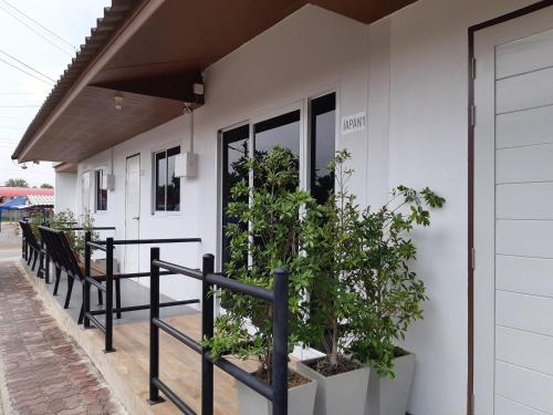 a white building with potted plants on the porch at The Chill House in Ban Wang Khanai