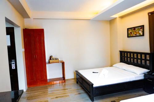 a bedroom with a bed and a red door at The Mang-Yan Grand Hotel powered by Cocotel in Puerto Galera