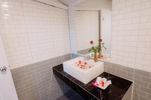 a bathroom with a white sink and a mirror at Coconut Grove Hotel Samui in Chaweng
