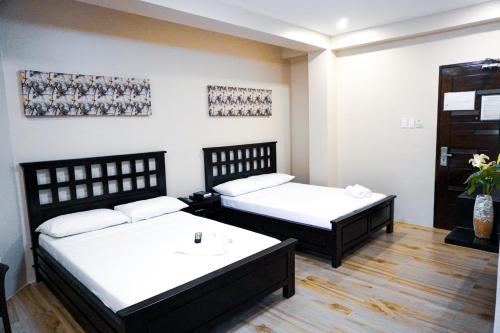 a room with two beds and a table at The Mang-Yan Grand Hotel powered by Cocotel in Puerto Galera