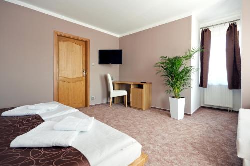 a hotel room with a bed and a desk at Vila Encore in Valašské Meziříčí